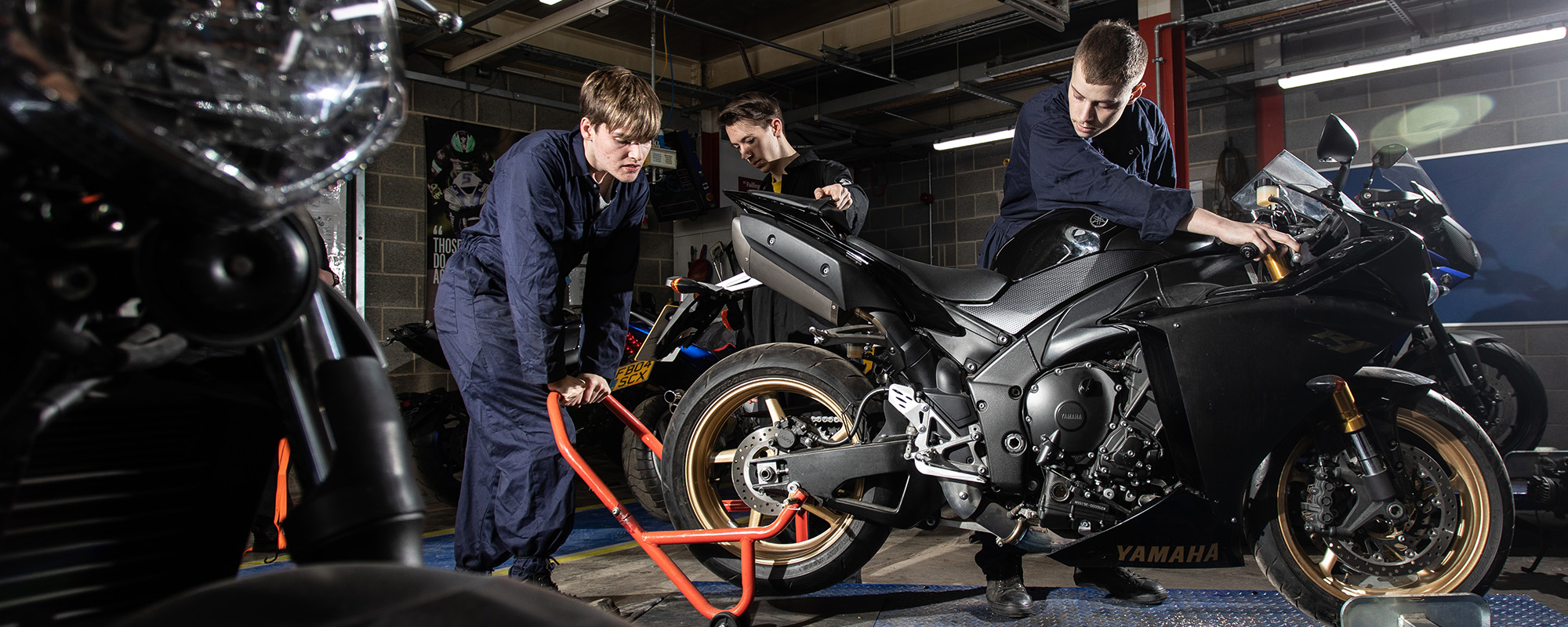 Automotive students working on a motor bike