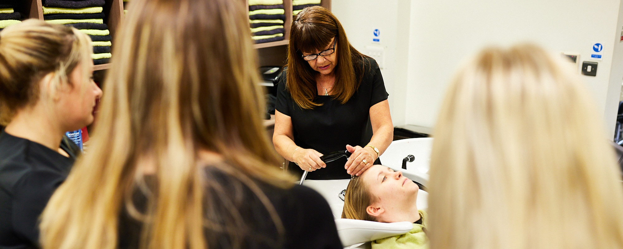 Hair and beauty tutor demonstrating to students