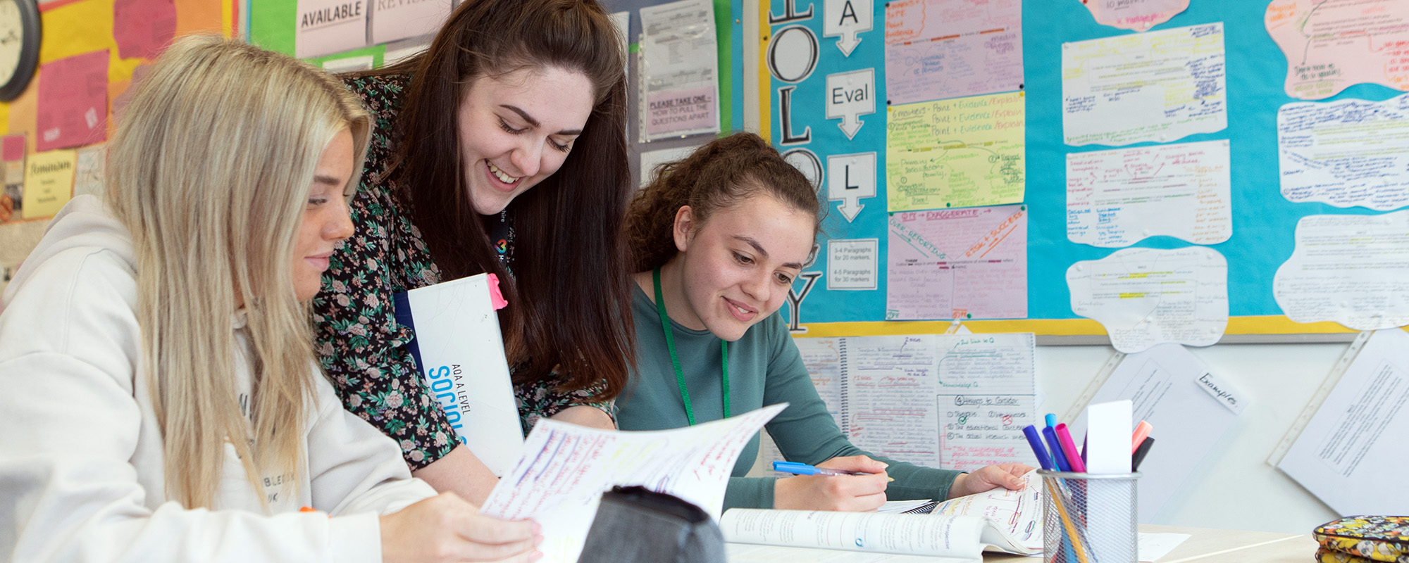 Two students with their tutor in class