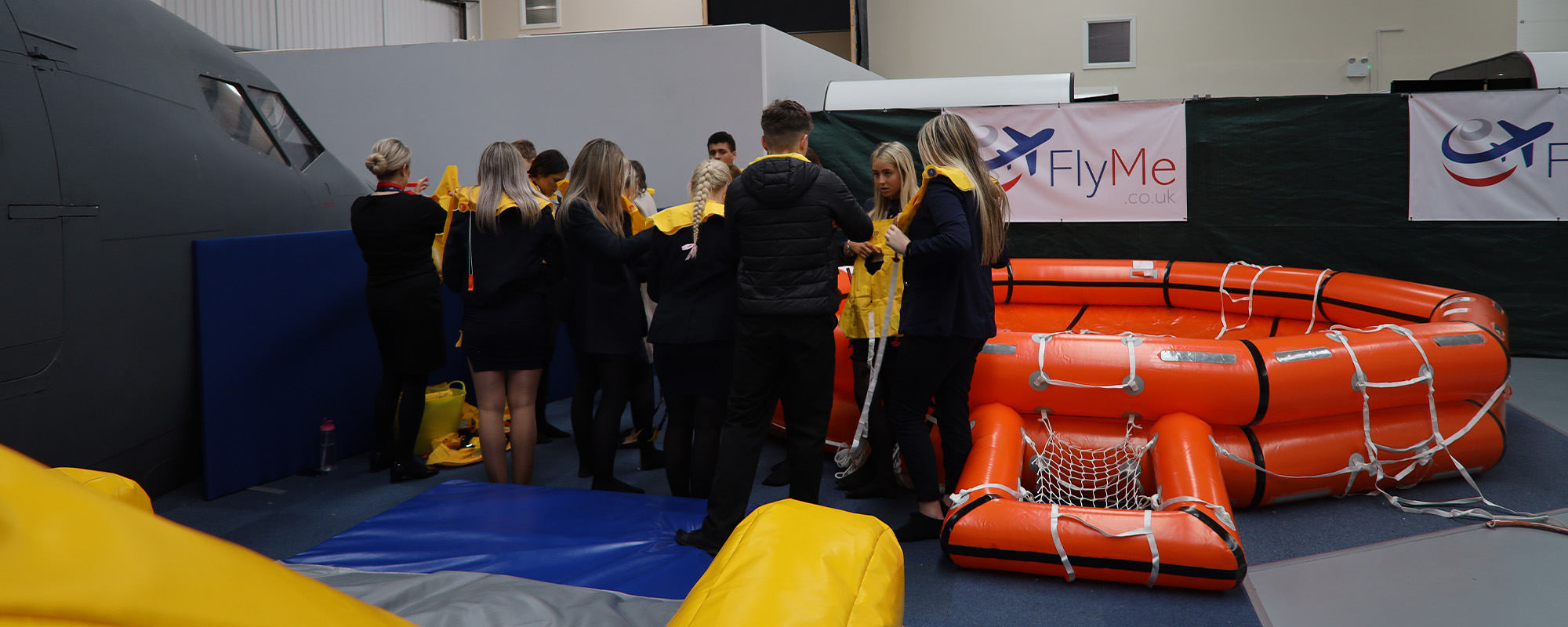 Group of students participating in emergency training by an inflatable raft