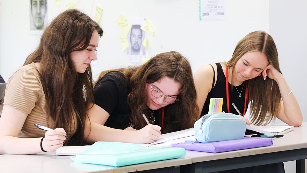 3 female students writing and studying