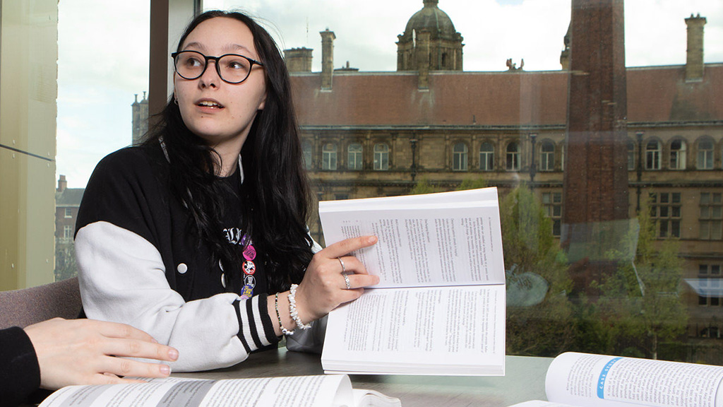 Female student pointing at a book