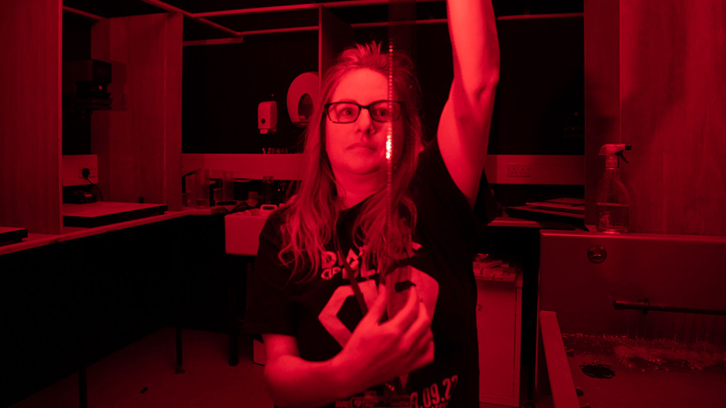 Student developing film in a photography dark room