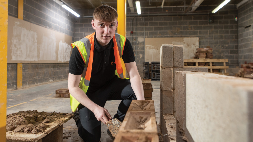 Student learning to lay bricks