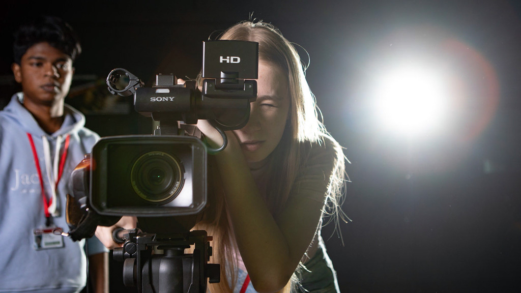 Student recording in the studio with a video camera