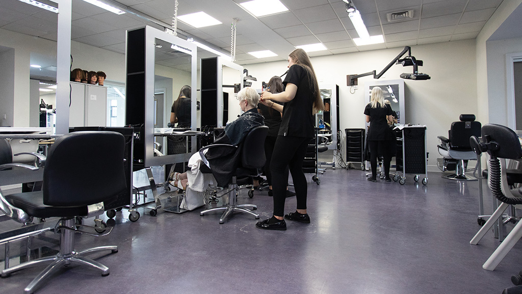 Students learning in working college salon