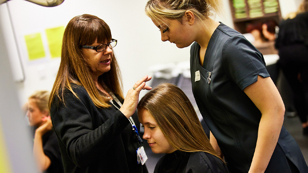 Tutor helps student with hair client