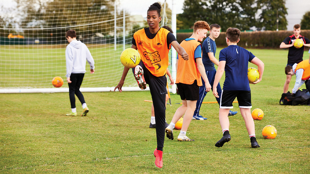 Student kicking up football