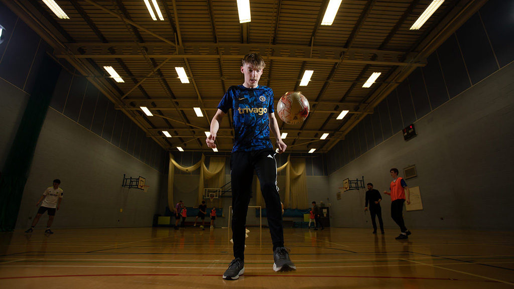 Student kicking up football